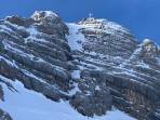 Dachstein mit Gipfelkreuz und am unteren Bildrand der Hallstätter Gletscher. Man erkennt recht gut Bergsteiger im Aufstieg.